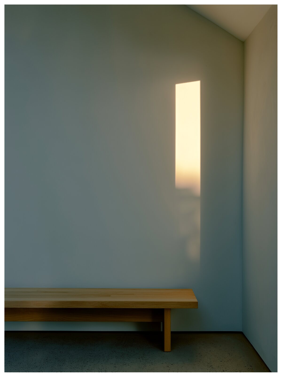 Late afternoon light on a plaster wall and an oak bench
